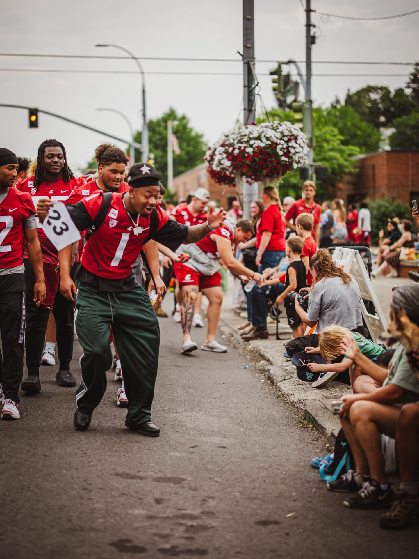 Cougar players high-fiving fans along the street during the team walk